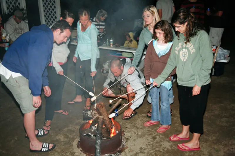 Guests roasting marshmallows around the firepit